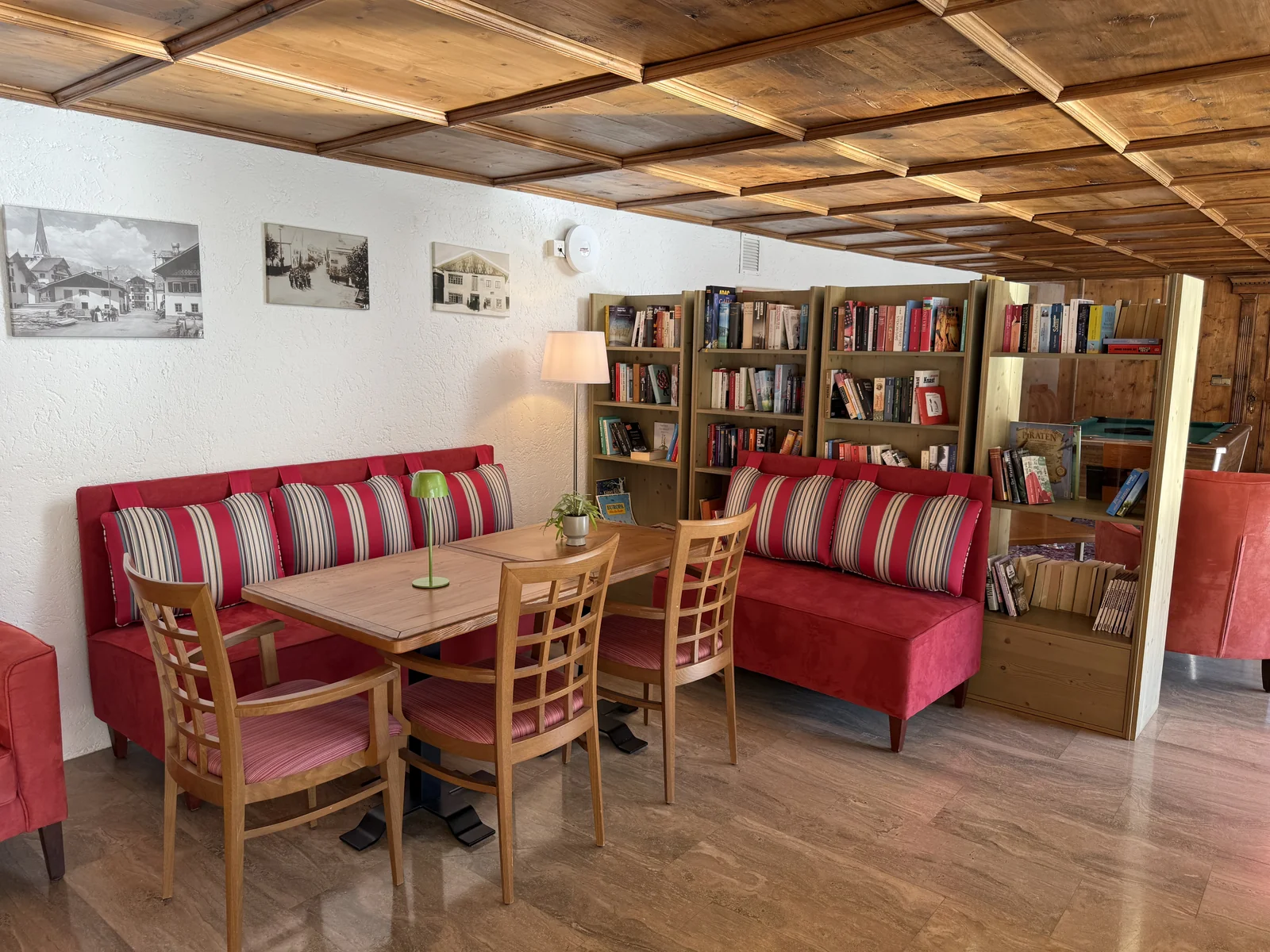 Bibliothek im Appartementhaus Birkenwald mit Bücherregalen und gemütlicher Sitzecke