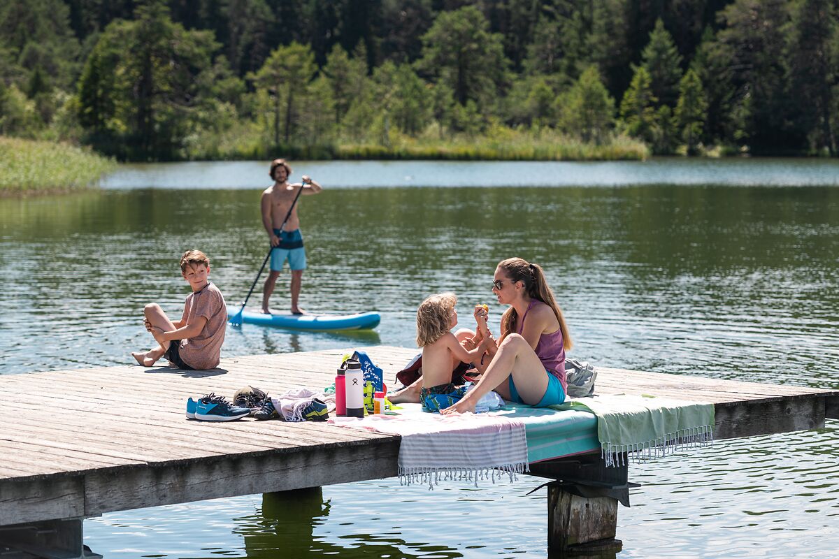 Familie am Steg eines Sees in Seefeld