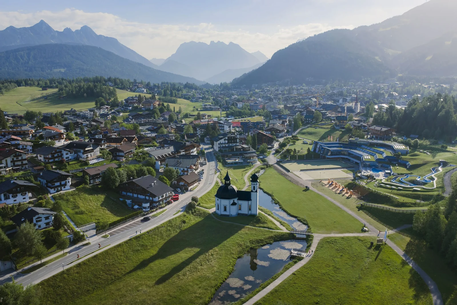 Drohnenaufnahme des Seekirchls und von Seefeld in sommerlicher Morgenstimmung